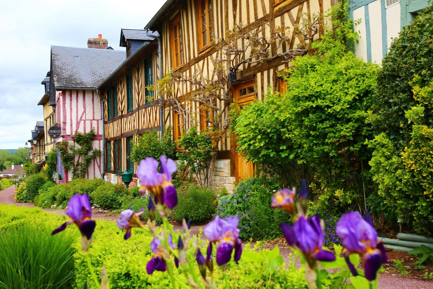 Fachwerkhäuser von Le Bec-Hellouin mit Blumen im Vordergrund