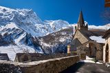 Kirche in La Grave mit Alpen und Gipfel des La Meije im Hintergrund im Winter