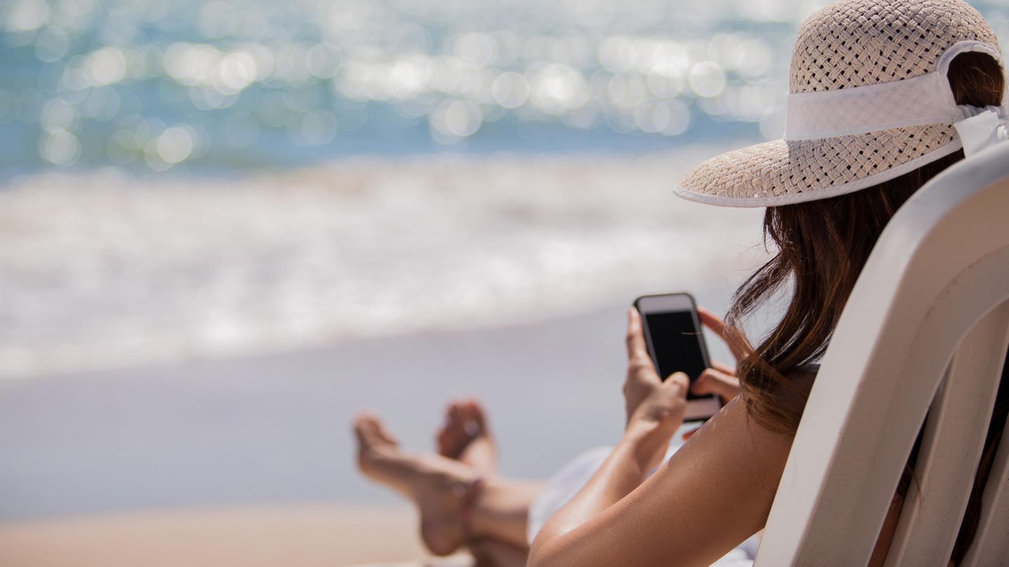 Frau mit Handy am Strand