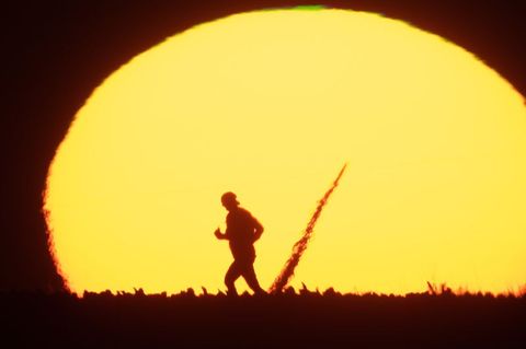 Silhouette eines Manns bei Sonnenaufgang