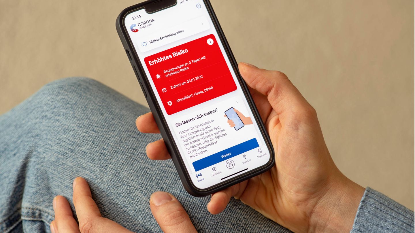 Warn-App ist rot und jemand hält sein Smartphone in der Hand