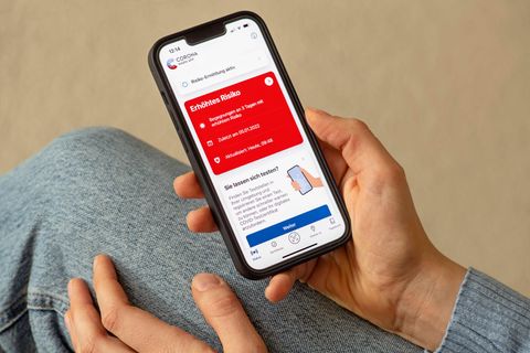 Warn-App ist rot und jemand hält sein Smartphone in der Hand