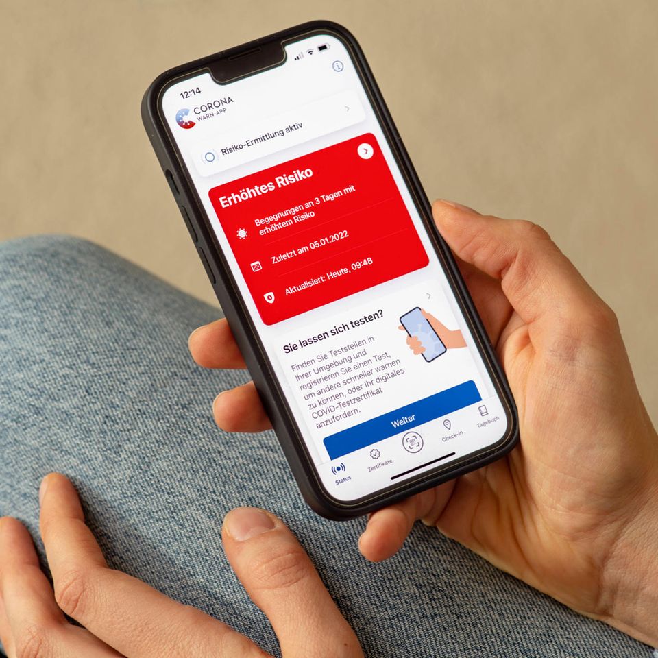 Warn-App ist rot und jemand hält sein Smartphone in der Hand