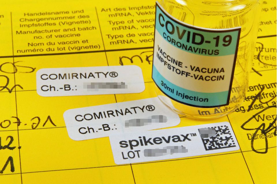 Booster Covid-19 Eintrag in einem Impfpass nach Impfung mit Moderna Impfstoff mit Impfampulle.