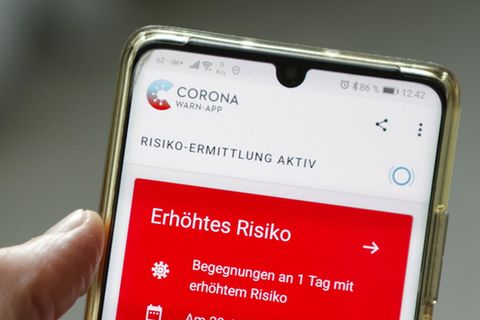 Eine Corona-Warn-App zeigt auf einem Handy ein erhöhtes Risiko an, mit einer an Corona infizierten Person Kontakt gehabt zu haben