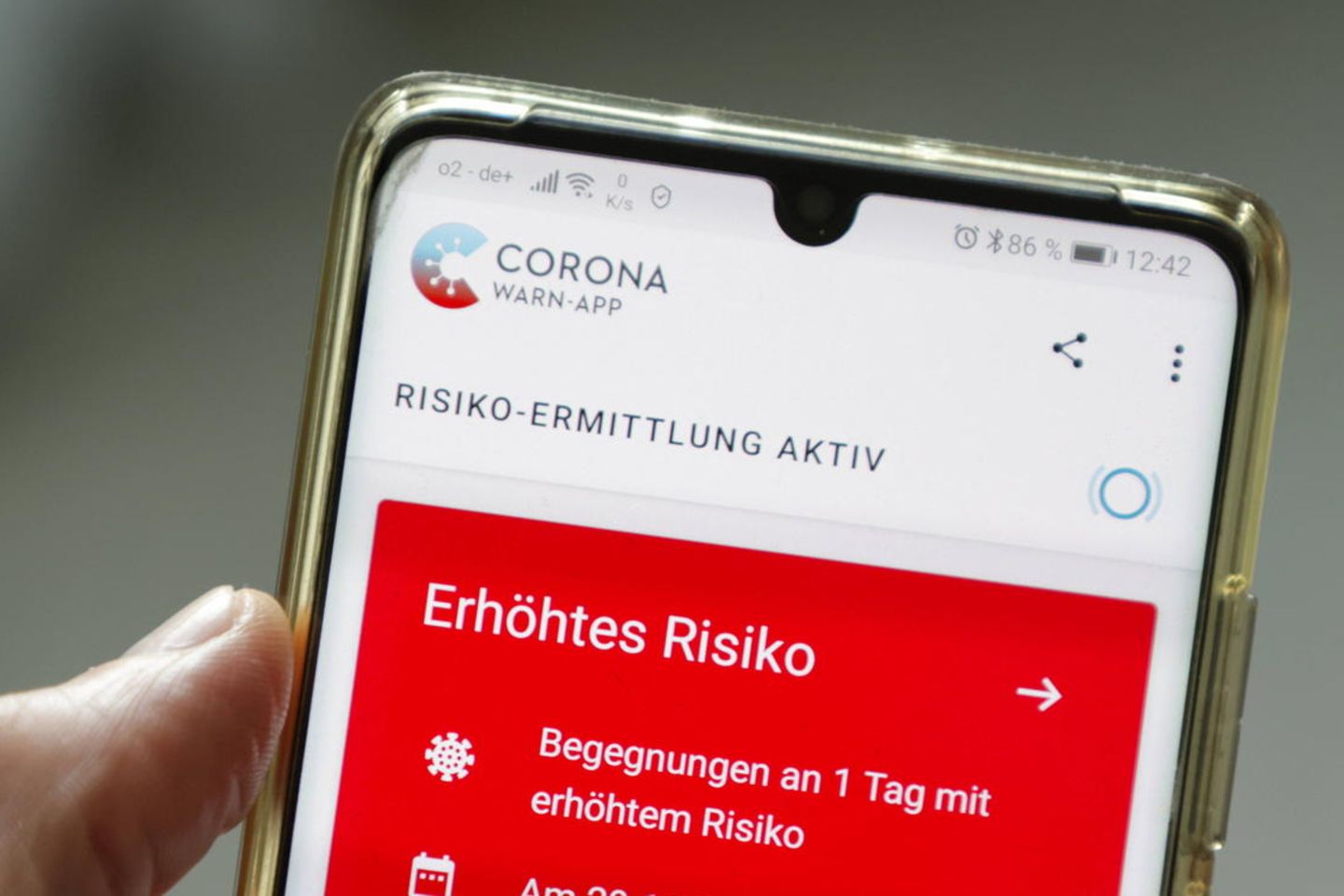 Eine Corona-Warn-App zeigt auf einem Handy ein erhöhtes Risiko an, mit einer an Corona infizierten Person Kontakt gehabt zu haben