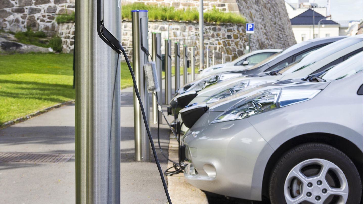 Silberne Elektroautos stehen parkend an Ladesäulen