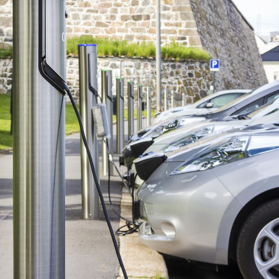 Silberne Elektroautos stehen parkend an Ladesäulen