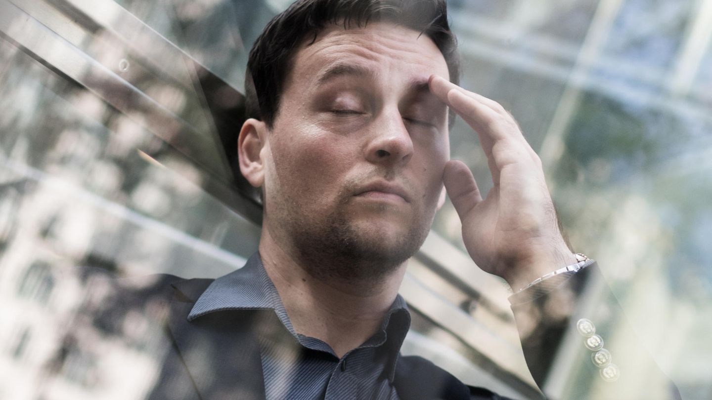 Mann ist gestresst und greift sich an den Kopf