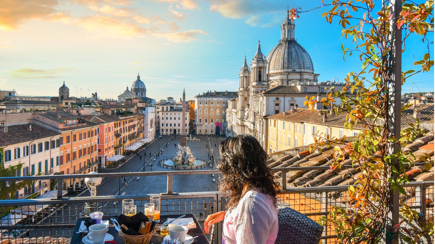 Platz 6: Rom Frau genießt die Sonne in einem Café in Rom mit Blick auf den Petersdom