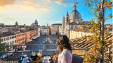 Frau genießt die Sonne in einem Café in Rom mit Blick auf den Petersdom