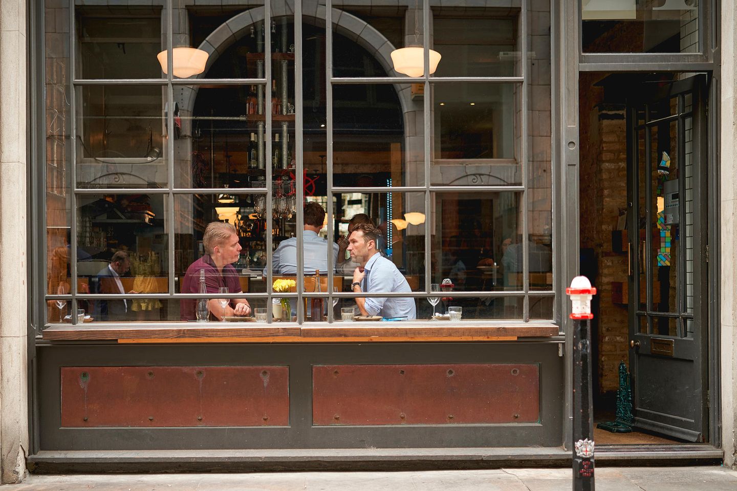 Männer hinter der Fensterscheibe eines Londoner Kaffeehauses