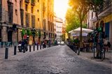 Straße mit Kopfsteinpflaster und kleinen Cafés in Madrid, Spanien