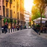 Straße mit Kopfsteinpflaster und kleinen Cafés in Madrid, Spanien