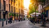 Straße mit Kopfsteinpflaster und kleinen Cafés in Madrid, Spanien