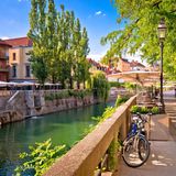 Flusspromenade in Ljubljana mit Cafés unter Bäumen