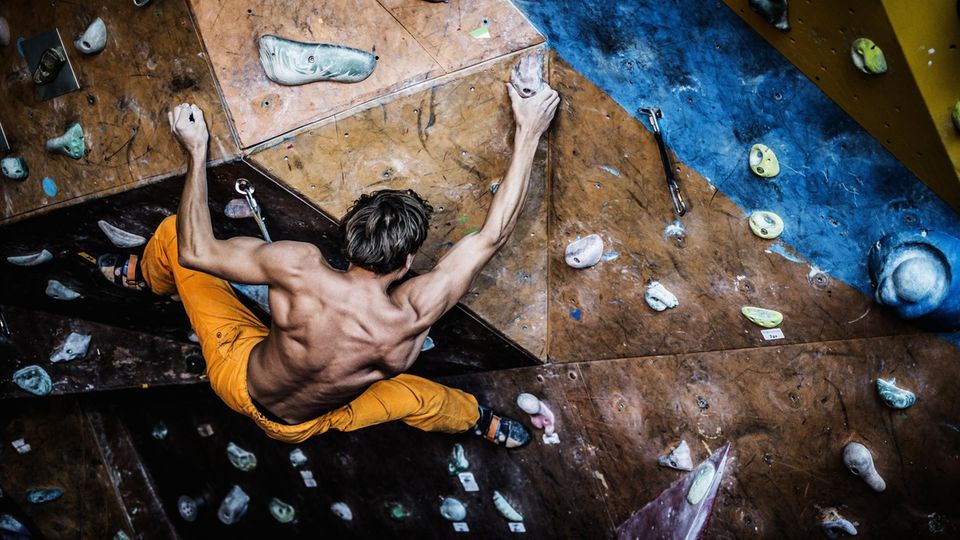 Ein Mann bouldert an einer überhängenden Wand. Ein Mann bouldert an einer überhängenden Wand.