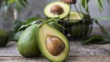 Aufgeschnittene Avocados liegen auf einem Holztisch