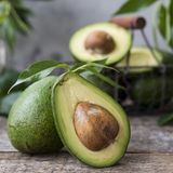 Aufgeschnittene Avocados liegen auf einem Holztisch