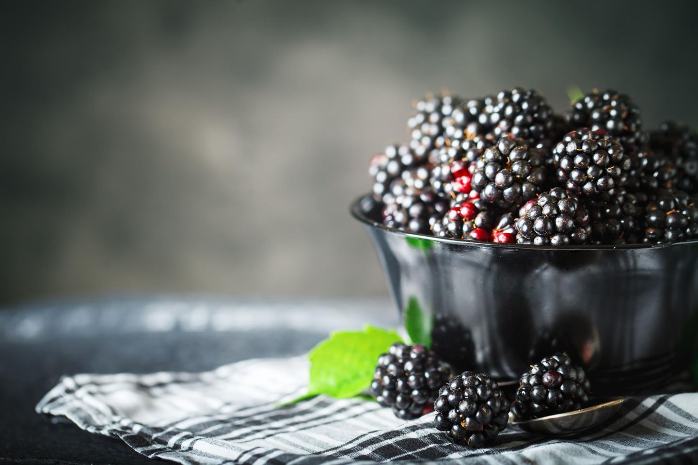 Brombeeren: 0,7 g Zucker und 43 kcal Brombeeren in einer Schüssel vor dunklem Hintergrund
