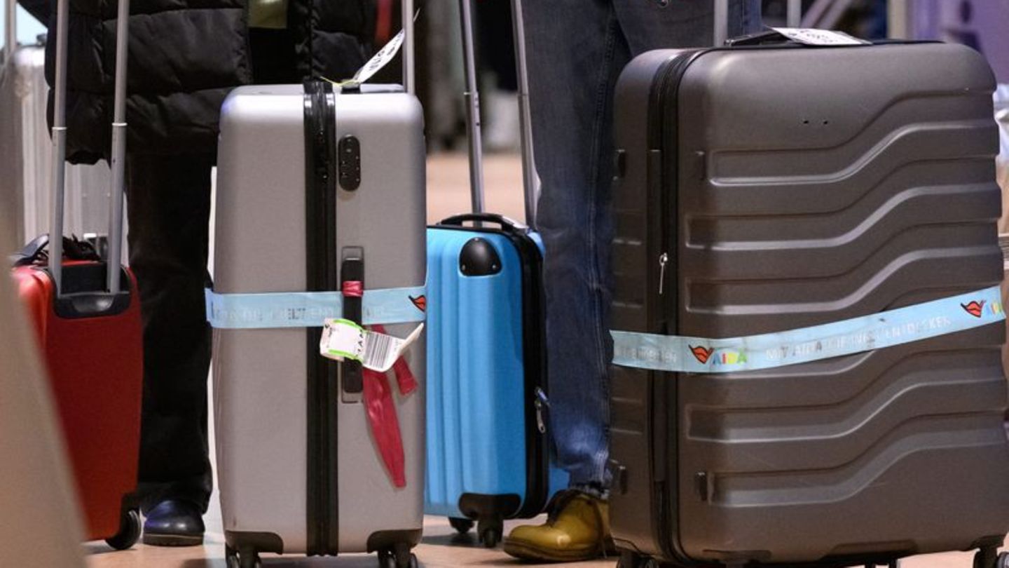 Reisende mit Koffern am Flughafen