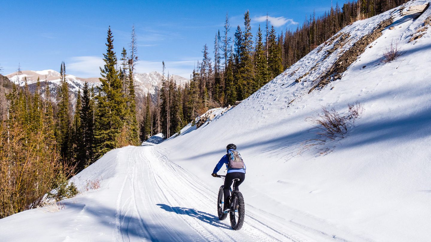 Mann fährt mit dem Fatbike durch den Schnee