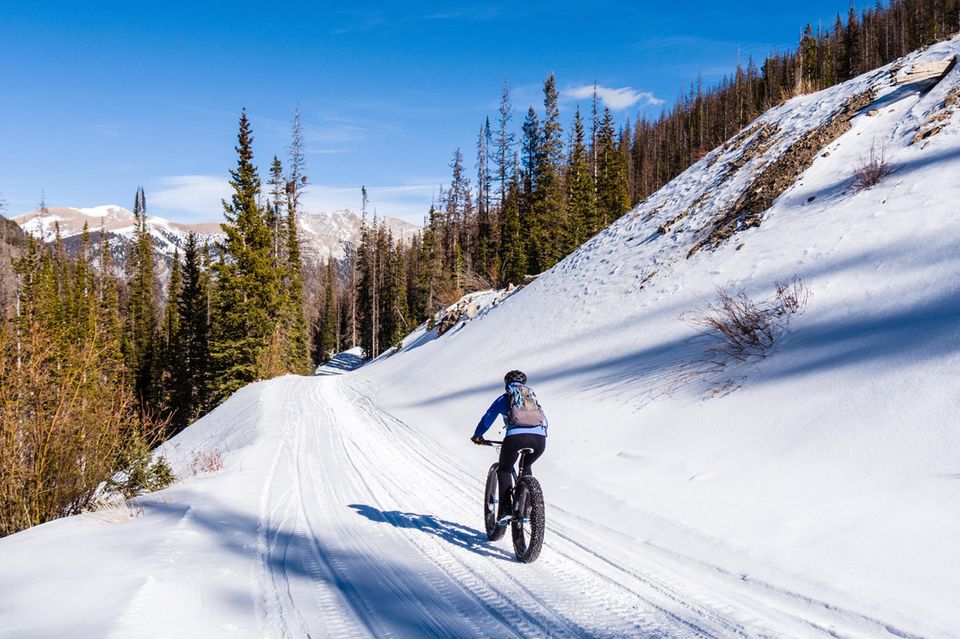 Mann fährt mit dem Fatbike durch den Schnee  1.3333