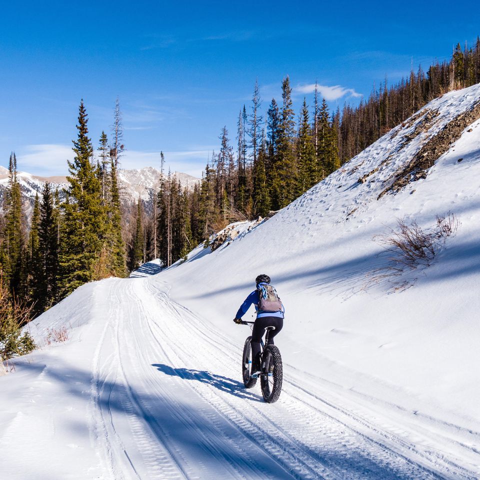 Mann fährt mit dem Fatbike durch den Schnee