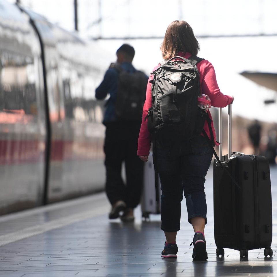 Frau mit Koffern am Bahnsteig