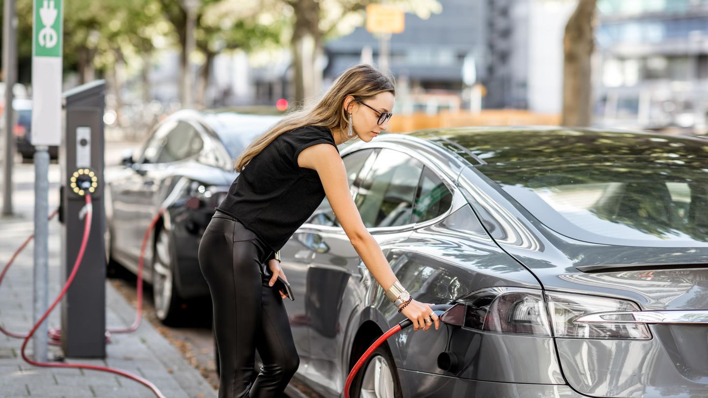 Frau lädt ihr Elektroauto auf
