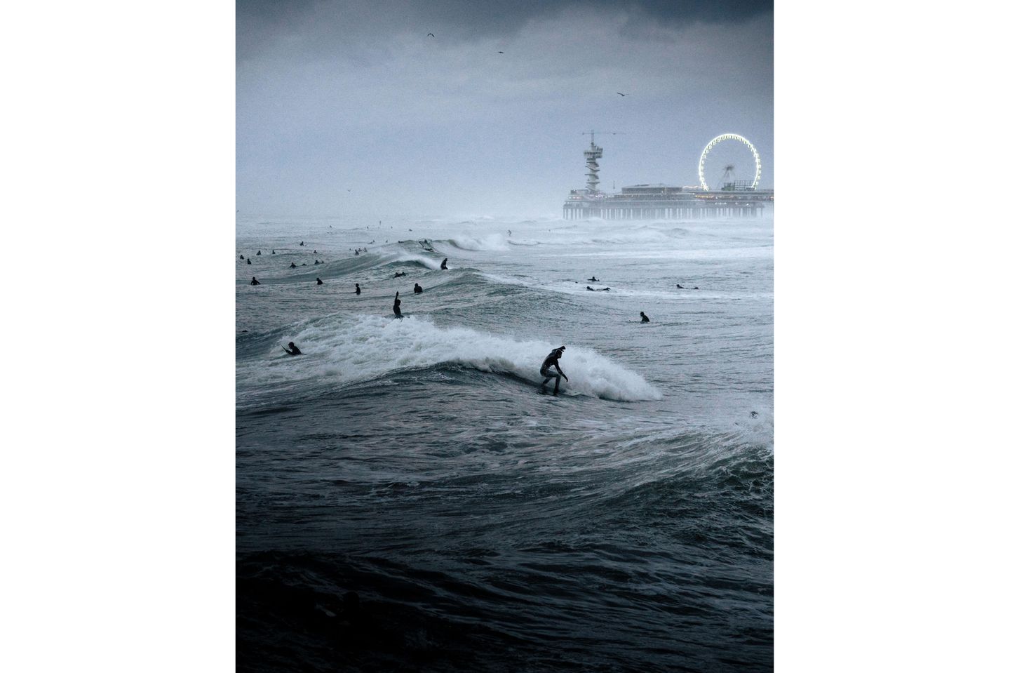Estland: "Surf-Festival" Image Name: Surfing Festival Photographer Name: Raido Nurk Year: 2022 Image Description: <p>The waves were the biggest I’ve ever seen in the evening when I took this photo in The Hague, Netherlands. The waves and the pouring rain created quite a unique atmosphere.</p> Copyright: © Raido Nurk, Estonia, Winner, National Awards, Motion, 2022 Sony World Photography Awards