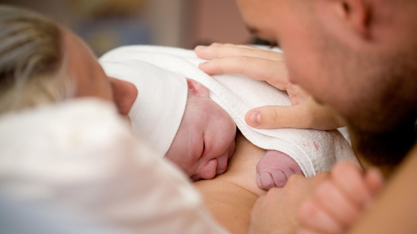 Frau und Mann mit neugeborenem Baby