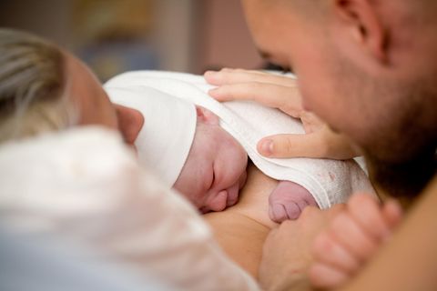 Frau und Mann mit neugeborenem Baby