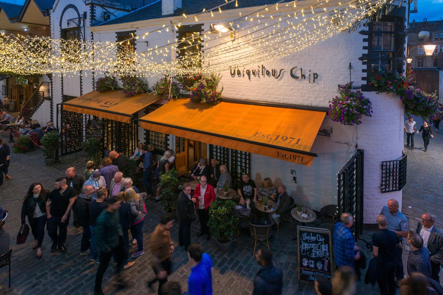 Ashton Lane Glasgow, Schottland. Die Ashton Lane, eine Gasse im West End von Glasgow, ist bekannt fuer seine Bars und Restaurants. In der Ausgehstrasse befindet sich auch das legendaere Restaurant Ubiquitous Chip, das schottische Kueche anbietet. Engl.: Glasgow Scotland. Ashton Lane in the West End of Glasgow. It is noted for its bars and restaurants. On the pub mile is the famous restaurant Ubiquitous Chip located. It is known for good Scottish cuisine.