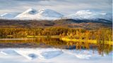 Verschneite Berge im Abisko Nationalpark spiegeln sich im See Vuolio Njáhkájávri