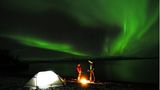 Nordlichter über einem Zeltlager im Abisko Nationalpark