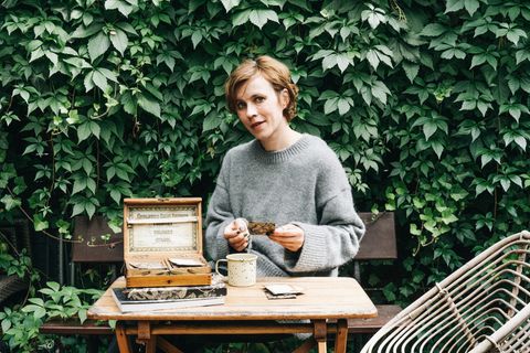 Carolin Engwert sitzt an einem alten Tisch im Garten