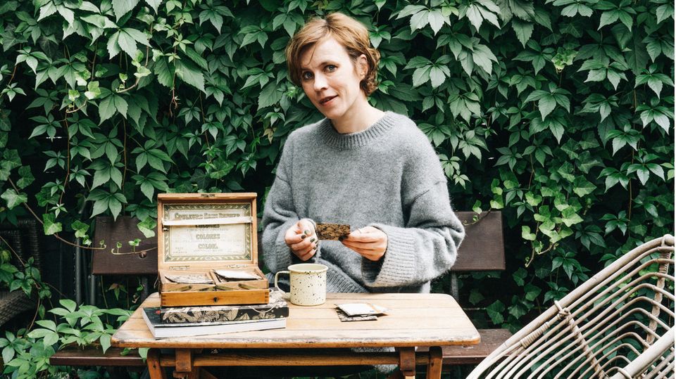 Carolin Engwert sitzt an einem alten Tisch im Garten