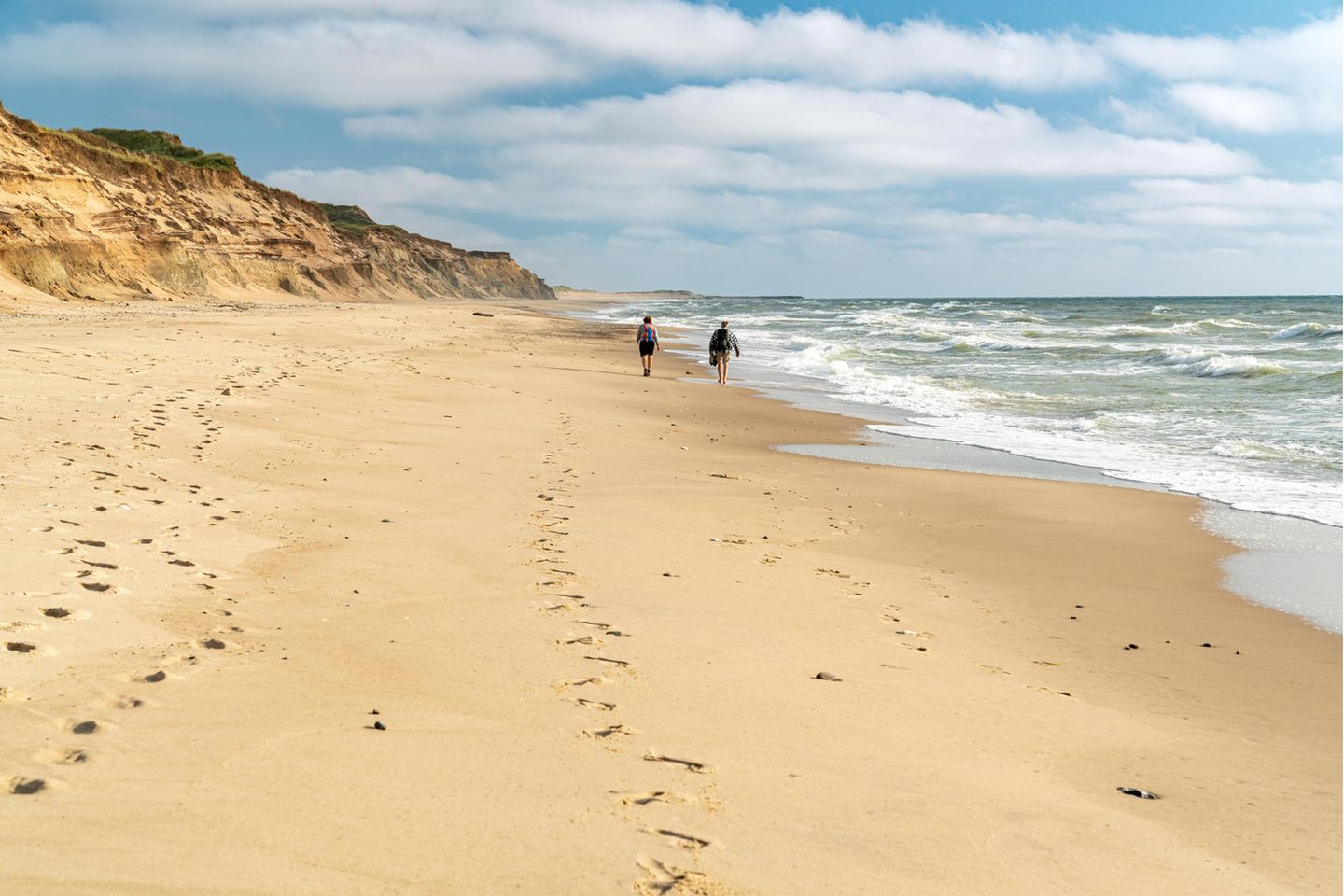 Ein Paar läuft den langen Strand im Nationalpark Thy  entlang