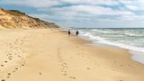 Ein Paar läuft den langen Strand im Nationalpark Thy  entlang