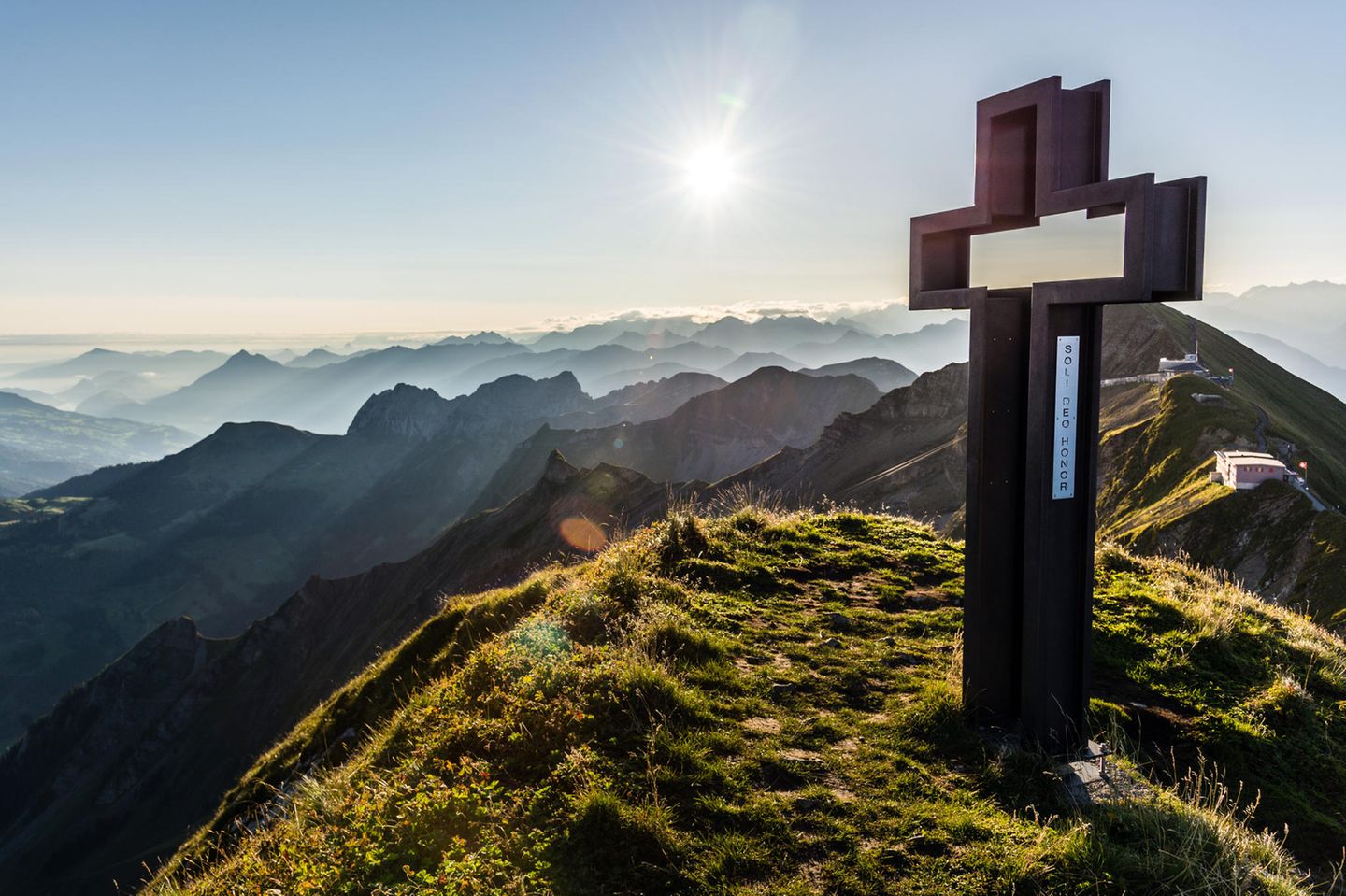 Hinauf auf den Brienzer Rothorn Gipfelkreuz Schöngütsch und Berge bei Sonnenaufgang vom Brienzer Rothorn aus gesehen