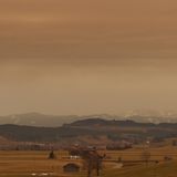 Bayern, Ruderatshofen: Saharastaub färbt den Himmel in rötliche Farbtöne