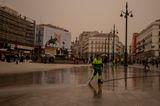 Madrid: Mitarbeiterin der Stadtreinigung reinigt den Sol-Platz von Wüstensand aus der Sahara mit Wasserschlauch