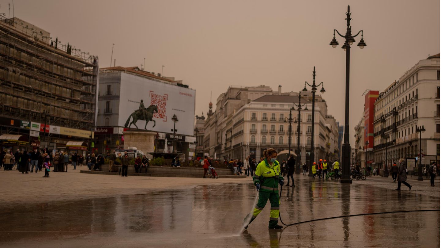 Madrid: Mitarbeiterin der Stadtreinigung reinigt den Sol-Platz von Wüstensand aus der Sahara mit Wasserschlauch