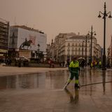 Madrid: Mitarbeiterin der Stadtreinigung reinigt den Sol-Platz von Wüstensand aus der Sahara mit Wasserschlauch