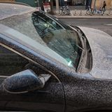 Ein Auto ist von rötlichem Staub bedeckt