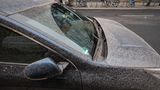 Ein Auto ist von rötlichem Staub bedeckt