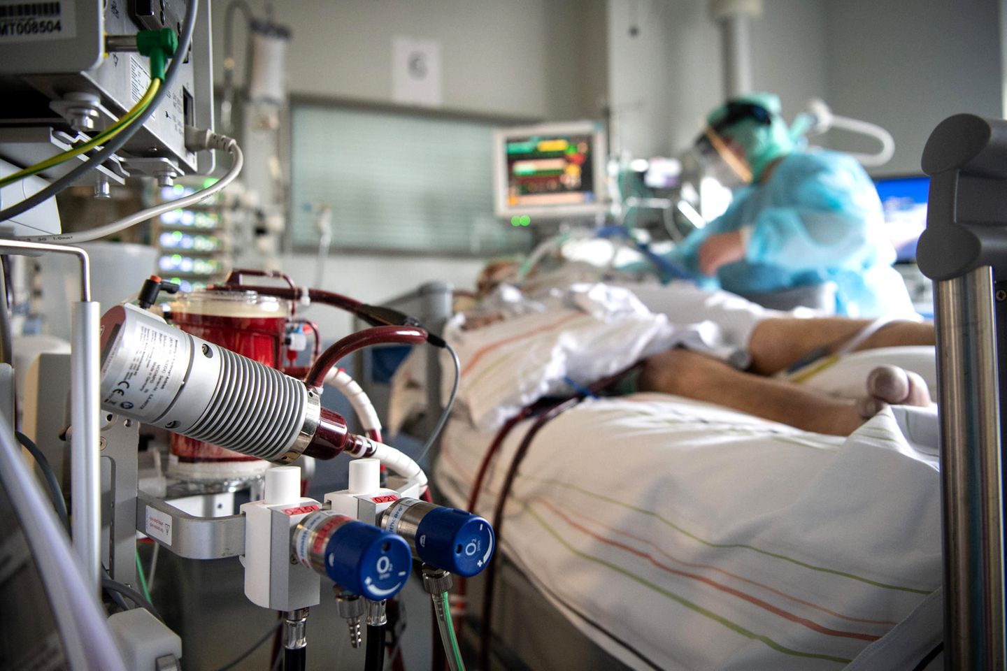 Eine Krankenschwester versorgt einen schwer an Corona erkrankten Patienten auf der Intensivstation des Klinikums in Fulda. Im Vordergrund steht eine ECMO-Maschine, an die der Mann angeschlossen ist. Viele Patienten mit schweren Verläufen liegen mehrere Wochen auf der Intensivstation, rund die Hälfte der künstlich beatmeten Patienten stirbt