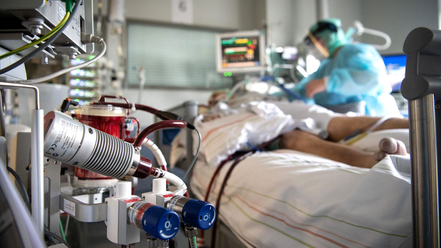 Eine Krankenschwester versorgt einen schwer an Corona erkrankten Patienten auf der Intensivstation des Klinikums in Fulda. Im Vordergrund steht eine ECMO-Maschine, an die der Mann angeschlossen ist. Viele Patienten mit schweren Verläufen liegen mehrere Wochen auf der Intensivstation, rund die Hälfte der künstlich beatmeten Patienten stirbt
