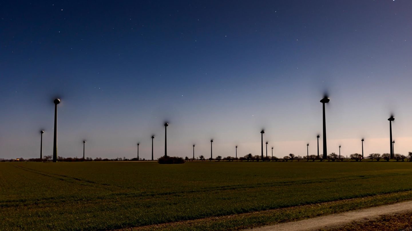 Der Mond scheint auf Windräder auf der Insel Fehmarn.